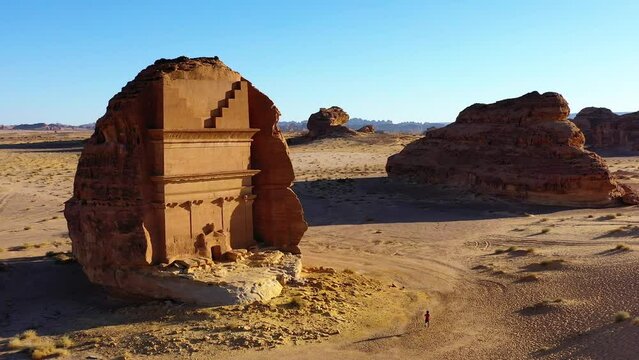 Aerial view of a man running in front of the Tomb Of Lihyan, son of Kuza, Qasr Al Farid, The Lonely Castle in sunny Hegra, Saudi Arabia