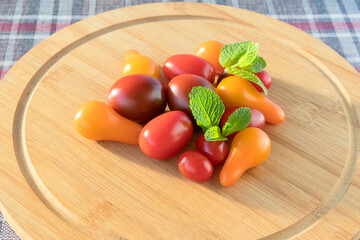 On a cutting wooden board an assortment of delicious cherry tomatoes. 
