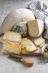 Closeup assortement of slices of soft cheeses on wooden board. Farm goat soft cheese background. Cornish Yarg cheese .