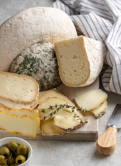 Closeup assortement of slices of soft cheeses on wooden board. Farm goat soft cheese background. Cornish Yarg cheese .