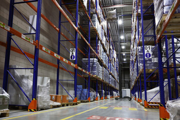 Warehouse interior with metal racks full of merchandise. Wholesale business