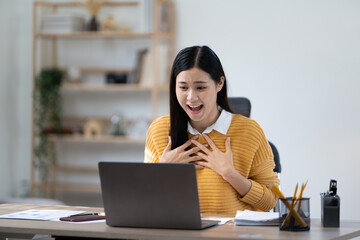 Young excited fun successful employee business woman she wear casual yellow shirt do winner gesture sit work at wooden office desk with pc laptop Achievement career concept
