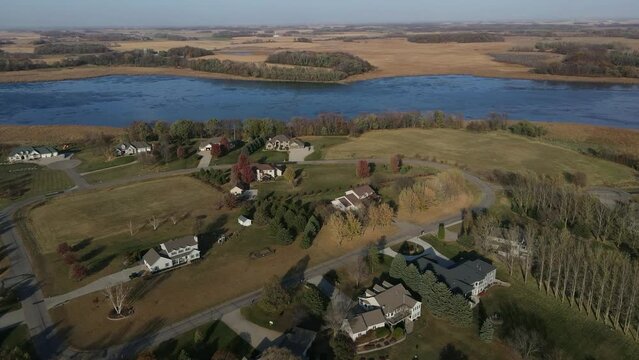 Aerial View of Rural Neighborhood in the Midwest. Lake , sky, and trees in the background. Cool Fall Day in Late October.