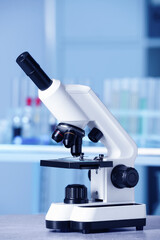 Modern medical microscope on gray table in laboratory