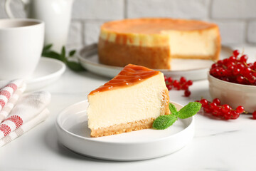 Piece of delicious caramel cheesecake served on white marble table