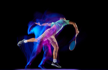 Young male tennis player in t-shirt and shorts playing tennis isolated over dark background in mixed purple neon light. Competition, creativity, art, ad