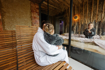 Mother with daughters in bath robe relaxing in the salt room with hay.