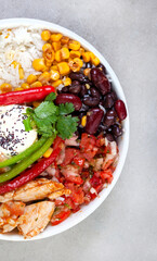 Chicken buddha bowl on mottled grey with copy space