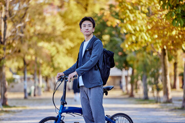 自転車に乗るジャケットを着た若い日本人の男性