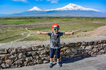 Little boy on the background of a beautiful view of mount Ararat in the afternoon. May 6, 2019....