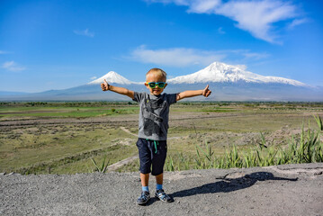 Little boy on the background of a beautiful view of mount Ararat in the afternoon. May 6, 2019. Armenia.