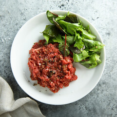Traditional homemade steak tartare with leaf salad