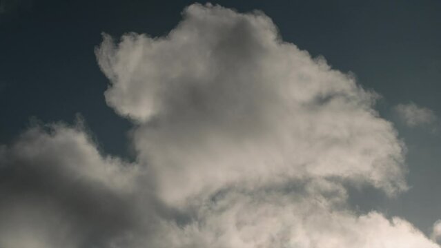 Time Lapse of clouds rolling past, backlit by late afternoon sun in springtime 4K