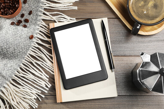 E-book reader with notebook and coffee on wooden table, flat lay. Space for text