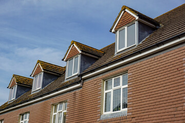 Fototapeta na wymiar roof tops of housing. Hip roof dormer windows of building. 
