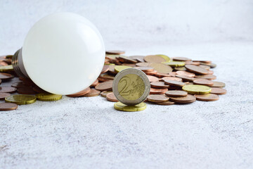 Close up, euro currency and more scattered, light bulb on top of them, electrical concept, energy...