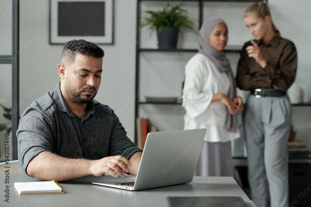 Poster young hispanic businessman networking or preparing project in front of laptop against two intercultu