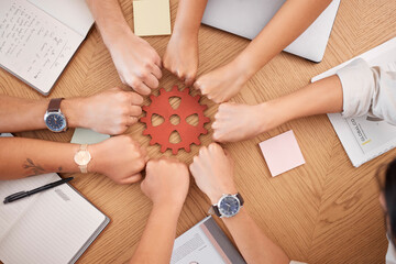 Hands, collaboration and gear with a business team working together at a table in the office from...