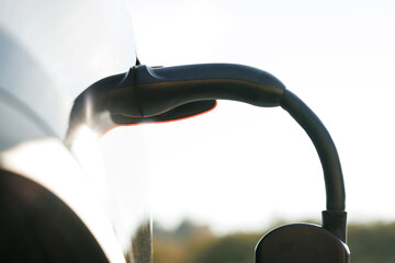 Electric vehicle charging port plugging in car. Charging technology, Clean energy filling...