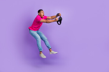 Full size profile photo of impressed person jumping arms hold wheel isolated on violet color...