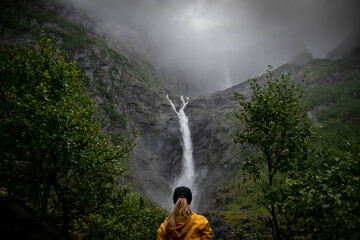 Woman hiker and foggy waterfall in Norway
