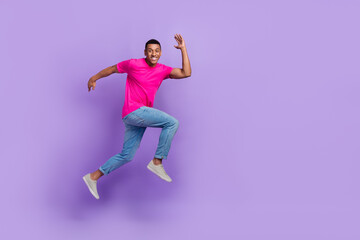 Fototapeta na wymiar Full length photo of excited energetic person jump run rush empty space isolated on violet color background