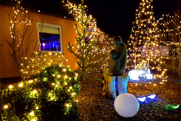 Danish home decorated with christmas lights and ornaments outside the house and in the garden in December