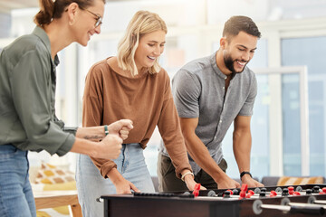 Business people play foosball table in office for team building competition, staff motivation or...