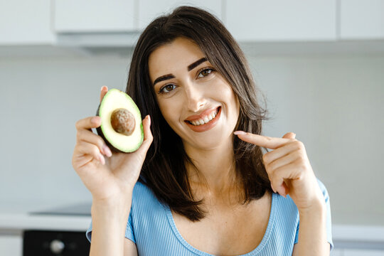 Female nutritionist show avocado fresh vegetables and a tape measure on her table .Concept of a healthy lifestyle, body care and weight loss. Selective focus. Blurred background.Home remote