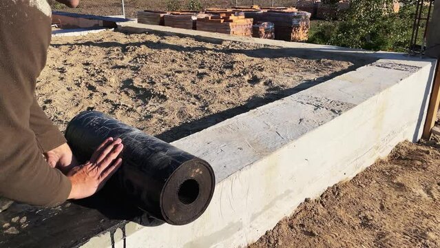 Construction work on waterproofing the foundation. Roll waterproofing