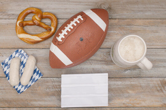 American football in Bavarian setting with wheat beer, white sausage and pretzel, symbol image for international game in Munich