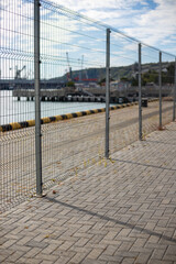 A metal fence closes the seaport.