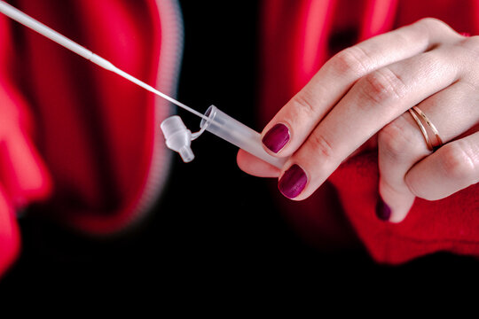 Unrecognizable woman putting pipette into extraction buffer