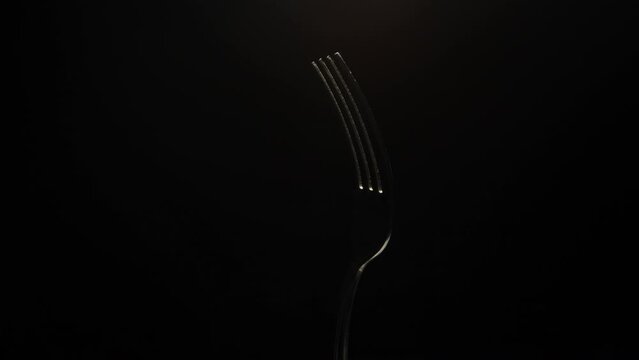 The fork is close-up, rotating on a black background.