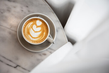 coffee in white cup on table in window cafe.