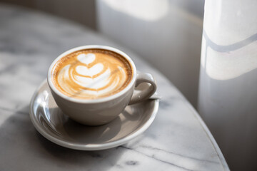 coffee in white cup on table in window cafe.
