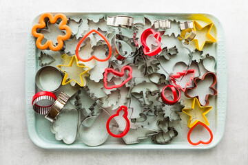 A baking tray filled with cookie cutters of all different shapes and sizes. - Powered by Adobe