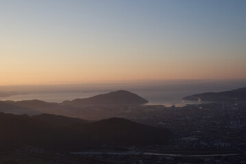 山頂から見る日の出と市街地