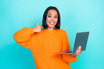 Photo of confident funny girl dressed orange pullover chatting modern gadget thumb up isolated teal...
