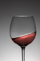 Vertical close up view of a tilted red wine cup.