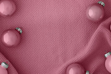 Cute Christmas rose pink colored balls on a knitted rose fabric.