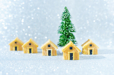 Miniature wooden cottages by a toy Christmas tree