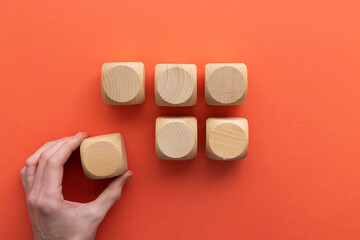Fototapeta na wymiar Hand choosing a wooden block from a set. Business choice concept