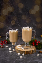 Christmas drink, cocoa with marshmallows on a dark concrete background with garland lights. A concept for holiday recipes and a winter menu. Festive mood new year