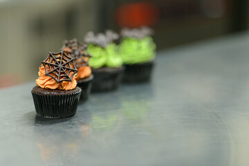 pastry chef baker preparing halloween green orange monster cupcakes handmade