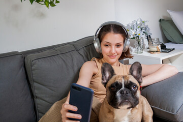 woman sitting with her dog using a cell phone