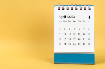 The April 2023 desk calendar on yellow color background.
