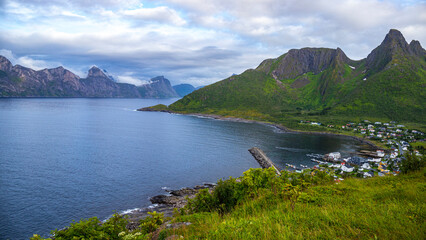 Fototapeta na wymiar gloomy landscape of the island of senja in northern norway; panorama of the island of senja, the norwegian fjords with their mighty rugged peaks rising out of the sea