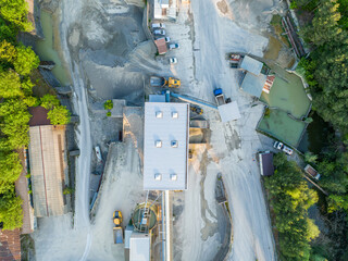Aerial view of industry plant in sand and gravel mine. Heavy machinery in pit: Dumper Truck and...