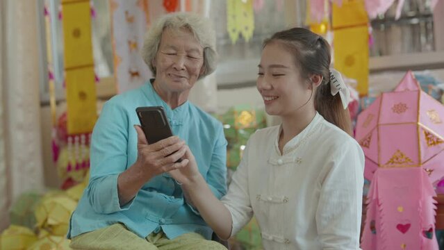 Granddaughter teach grandmother using smartphone chatting, take the photo and VDO call.